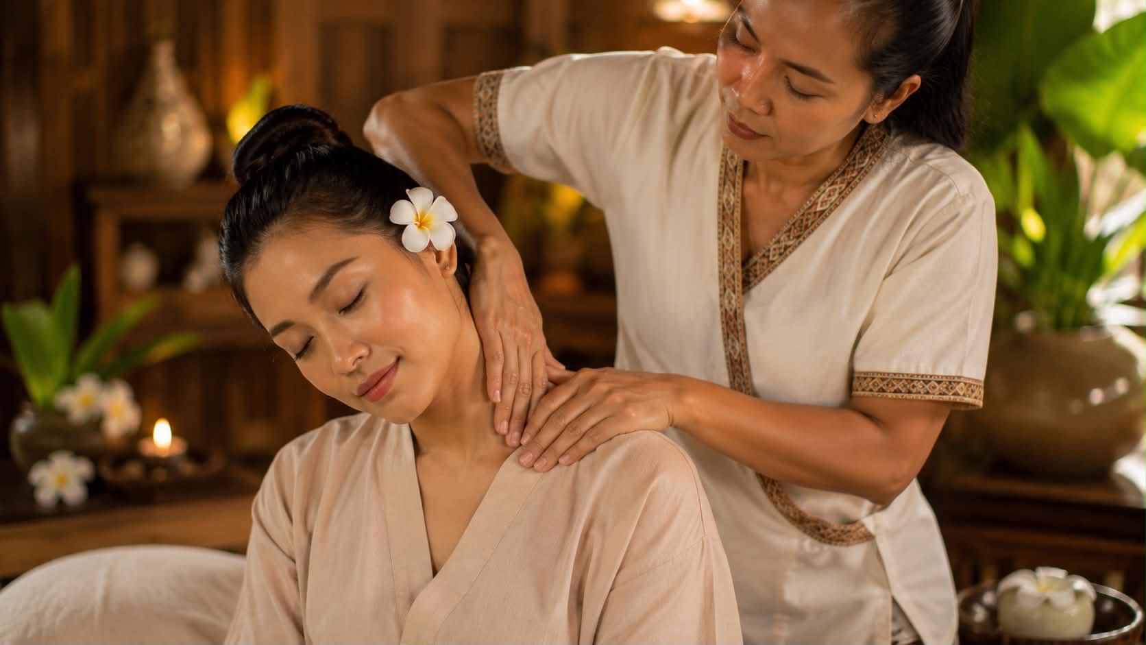 A therapist working a guest's shoulders during a traditional Thai massage.